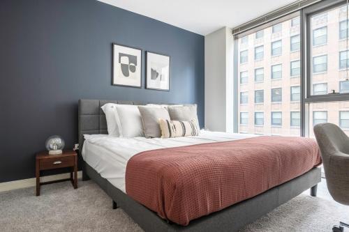 a bedroom with a large bed and a blue wall at Loop 1BR w Gym Pool WD nr Financial District CHI-238 in Chicago