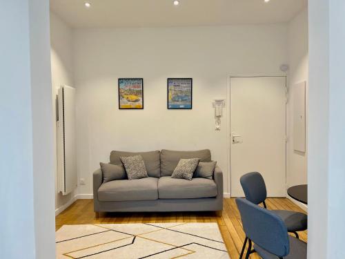 a living room with a couch and two chairs at Suite Clovis 2 in Reims