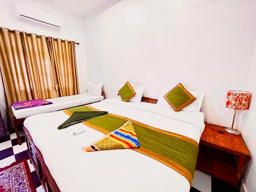 two beds in a room with white walls at Red Sea Beach Resort in Anjuna