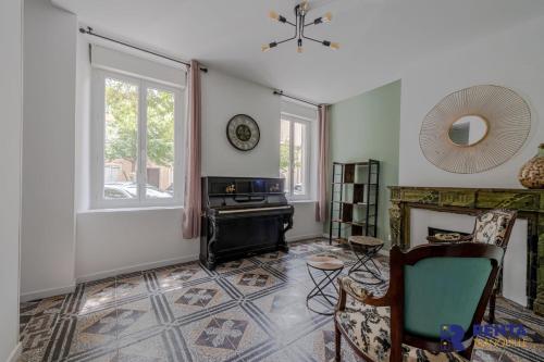 a living room with a fireplace and a clock on the wall at Chez Yvette 3 WIFI Near the sea in Leucate