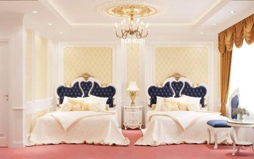 a bedroom with two beds and a chandelier at Hoang Gia Hotel Ha Noi Capital in Hanoi