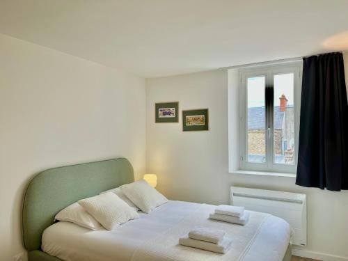 een slaapkamer met een bed met twee handdoeken erop bij Suite Clovis 7 in Reims