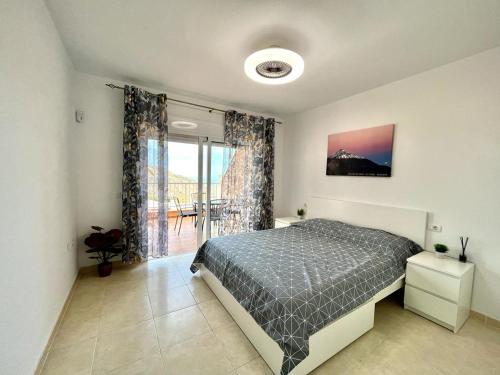 a bedroom with a bed and a large window at One bedroom apartment ZEN with great view, pool, WiFi in Chayofa