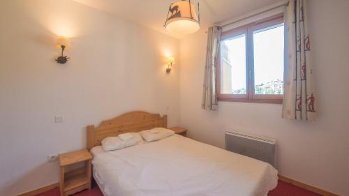 une chambre avec un lit blanc avec une fenêtre dans l'établissement A012- Appartement 3 pieces cabine 8 personnes-, à Orcières