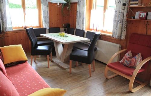 a dining room with a table and chairs and windows at utas ferienhof in Sankt Gallenkirch