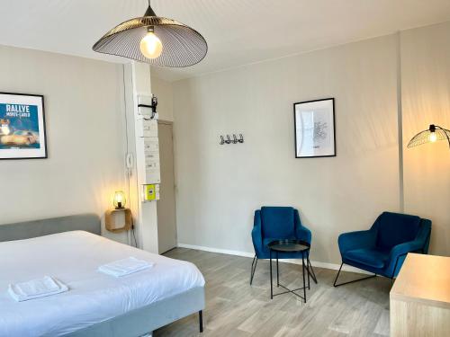 - une chambre avec un lit et deux chaises bleues dans l'établissement Suite Orphelins 3 1er, à Reims