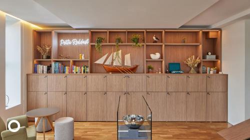 una habitación con un estante de libros con un barco. en Center Hotels Arnarhvoll en Reikiavik