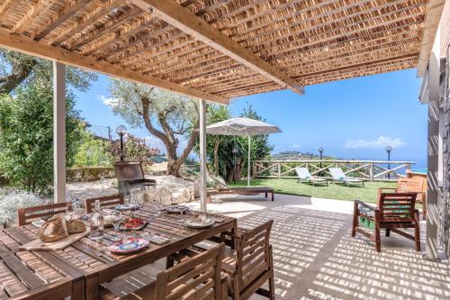 an outdoor patio with a wooden table and chairs at Maison Annie - Mental Wellness Retreats in Sorrento