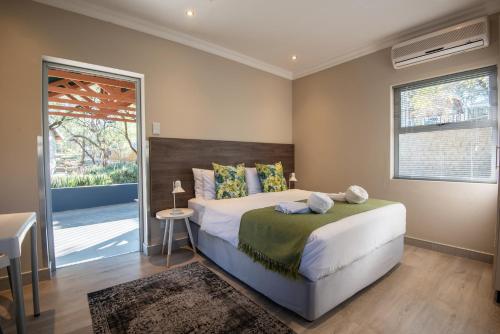 um quarto com uma cama grande e uma janela em Arebbusch Travel Lodge em Windhoek