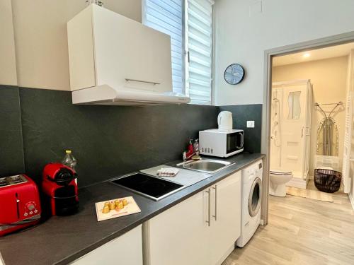 a small kitchen with a sink and a microwave at Suite Orphelins 2 (rdc) in Reims