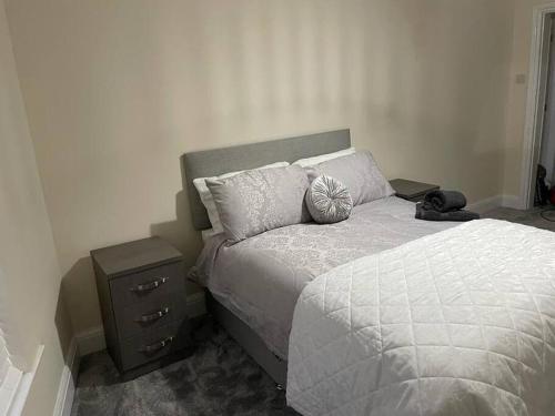 a bedroom with a bed and a nightstand next to a bed at Lighthouse View - Lovely 3 bed 1st floor apartment in Fleetwood