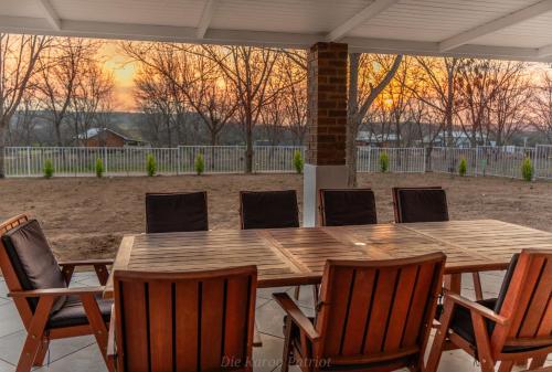 a wooden table and chairs on a patio at Die Karoo Patriot in Orania
