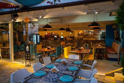 a restaurant with tables and chairs and a kitchen at Bougainville Bay Apartments in Sarandë