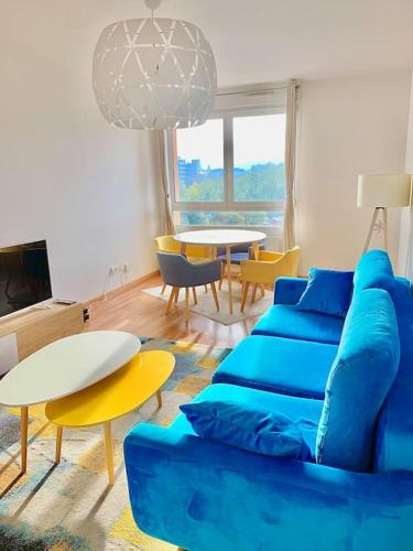 - un salon avec un canapé bleu et une table dans l'établissement Golden Star, à Schiltigheim