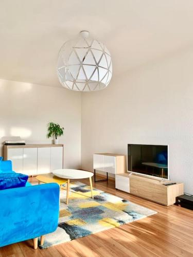 un salon avec un canapé bleu et une télévision dans l'établissement Golden Star, à Schiltigheim