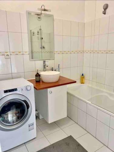 a bathroom with a washing machine and a sink at Golden Star in Schiltigheim