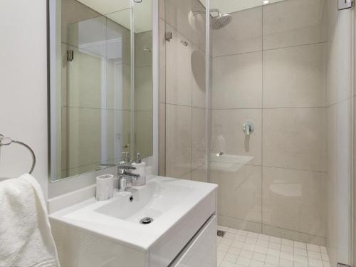 La salle de bains blanche est pourvue d'un lavabo et d'une douche. dans l'établissement Ellipse Waterfall 3902, à Midrand