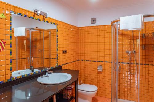 La salle de bains orange est pourvue d'un lavabo et de toilettes. dans l'établissement La Casita Verde de Cabárceno, à Sobarzo