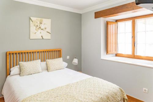 um quarto com uma cama e uma janela em La Casita Verde de Cabárceno em Sobarzo