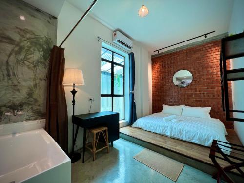 怡保的住宿－DoSomething Guest House 8，一间卧室设有砖墙、一张床和一个浴缸