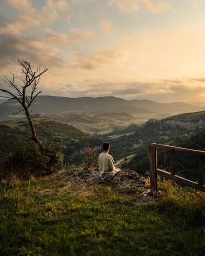 a man sitting on top of a hill overlooking a valley at Alereks Mountain Camping in Dsegh