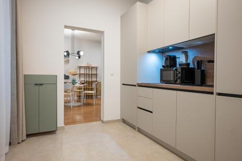 a kitchen with white cabinets and a dining room at 42 m2 central bright apartment with a terrace in Vienna