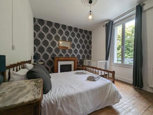 - une chambre avec un lit blanc et une cheminée dans l'établissement Maison des années 30 - Vic-Sur-Cère - 14 personnes, à Vic-sur-Cère