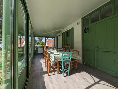 une salle à manger avec une table et des chaises sur un patio dans l'établissement Maison des années 30 - Vic-Sur-Cère - 14 personnes, à Vic-sur-Cère