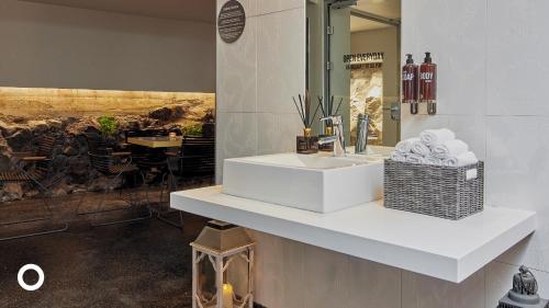 a bathroom with a sink with a basket of towels at Center Hotels Arnarhvoll in Reykjavík