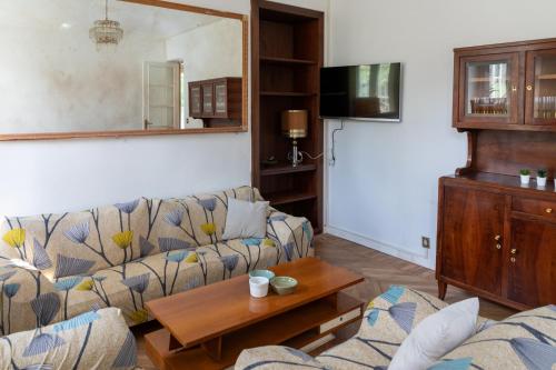 uma sala de estar com um sofá e uma mesa em Maison Cècile Appartamento in villa. Host Marianna em Agliè