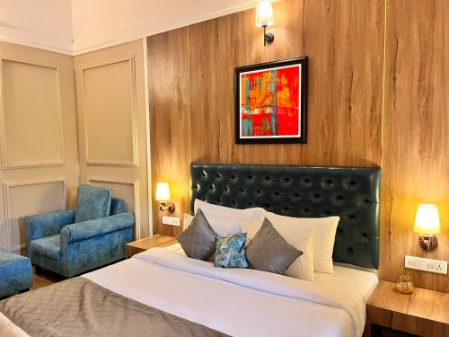 a bedroom with a bed and a blue chair at Pushpam Sanskruti Resort Karjat- Pure Veg in Karjat