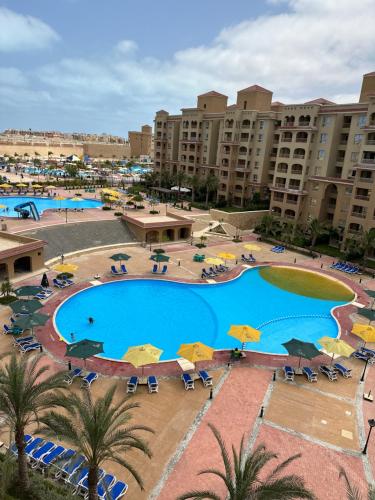 uma vista aérea de uma piscina de resort com guarda-sóis em قريه اكوا فيو الساحل الشمالي em El Alamein