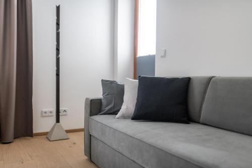 a gray couch with pillows in a living room at Kaisigen43 in Steinbach am Attersee