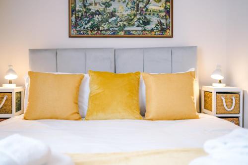 a bedroom with a white bed with yellow pillows at Albion Cottage in Chester