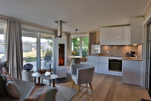 cocina y sala de estar con sofá y mesa en Frei wie der Wind-Chalets, en Dierhagen