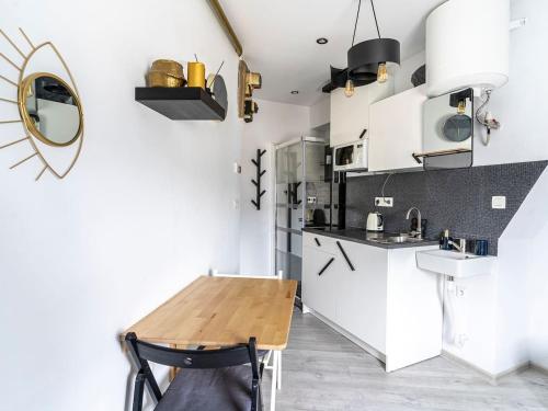 une cuisine avec des armoires blanches et une table en bois dans l'établissement Paris Dream Apart Nord, à Paris
