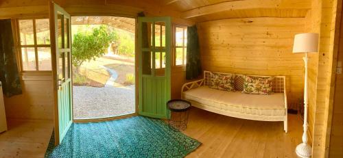 カンディアにあるEudaimonia Wooden Suites Nafplio Kandiaのログキャビン内のベッド1台が備わる小さな客室です。