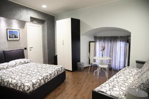 a hotel room with two beds and a table at Duomo Bed & Breakfast in Catania