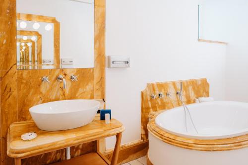 a bathroom with a large tub and a sink at Hotel Marina Riviera in Amalfi