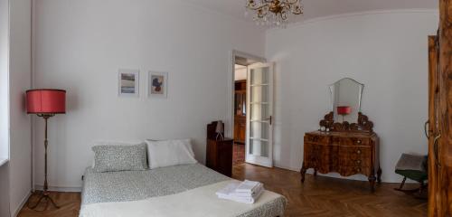 a white room with a bed and a table at Maison Cècile Appartamento in villa. Host Marianna in Agliè