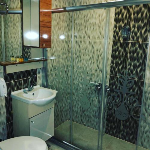 W łazience znajduje się prysznic, toaleta i umywalka. w obiekcie Grand Mardin Hotel w mieście Mersin