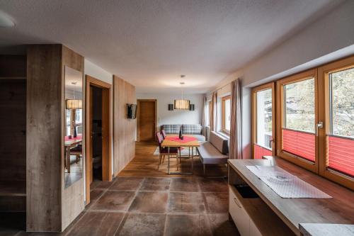 salon ze stołem i kilkoma oknami w obiekcie Gästehaus Fohringer w mieście Kelchsau