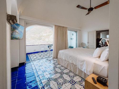 a hotel room with a bed and a large window at Hotel Marina Riviera in Amalfi