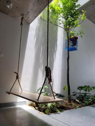 a swing in a room with a tree at Noi Bai Flight Path Homestay in Hanoi