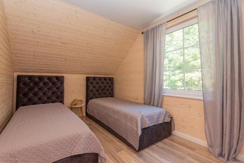 um quarto com 2 camas e uma janela em Sodyba pas Brolius - Mažasis Namelis - Entire Barn House 85m2 em Priekulė