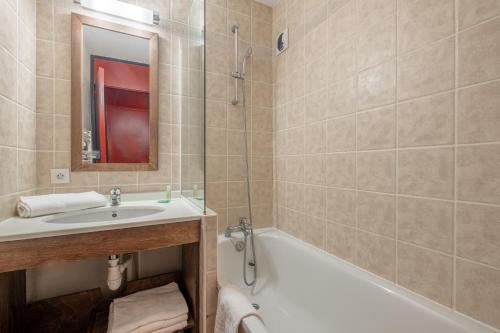 a bathroom with a sink and a tub and a toilet at Résidence Pierre & Vacances Le Quartz in Belle Plagne