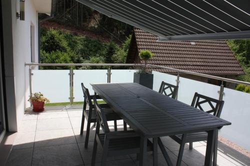 une table noire et des chaises sur un balcon dans l'établissement A l Orée du Bois, à Rimbach-près-Masevaux