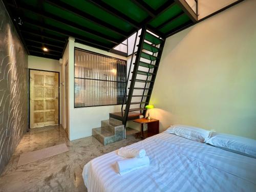 um quarto com uma cama e uma escada em espiral em DoSomething Guest House 2 em Ipoh