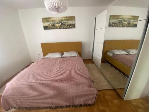 1 dormitorio con 1 cama grande y espejo en Apartment DELS en Zenica