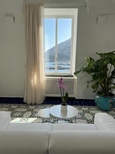 a living room with a white couch and a window at Hotel Marina Riviera in Amalfi